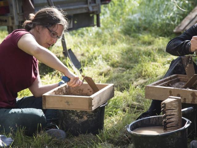 Anmischen von Lehm | Foto: Hendrik Silbermann (ARTWORKs) Anmischen von Lehm in einer Holzbox durch eine Teilnehmerin. | Foto: Hendrik Silbermann (ARTWORKs)