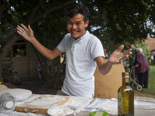 Vorbereitung der Speisen für das Backen im Ofen. | Foto: Hendrik Silbermann (ARTWORKs) Vorbereitung der Speisen für das Backen im Ofen durch einen fröhlichen jungen Mann. | Foto: Hendrik Silbermann (ARTWORKs)