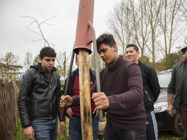 Ein Baum wurde gepflanzt, daraufhin wurden die Pfosten zur Stabilisierung befestigt. | Foto: Hendrik Silbermann (ARTWORKs) Ein Baum wurde gepflanzt, daraufhin wurden die Pfosten zur Stabilisierung befestigt. Teilnehmende stehen um den Schauplatz drumherum. | Foto: Hendrik Silbermann (ARTWORKs)