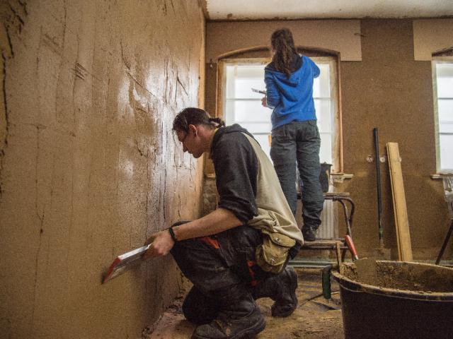 Abziehen des Ausgleichsputzes mit einer Kardätsche. | Foto: Hendrik Silbermann (ARTWORKs) Abziehen des Ausgleichsputzes mit einer Kardätsche durch einen Teilnehmenden. | Foto: Hendrik Silbermann (ARTWORKs)